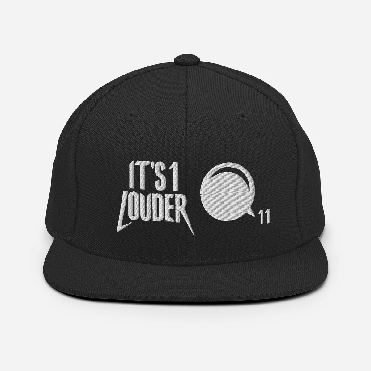 Black flat brim snapback baseball cap with embroidered IT'S 1 LOUDER text and a volume knob turned to 11 in white thread, rock and metal headwear.