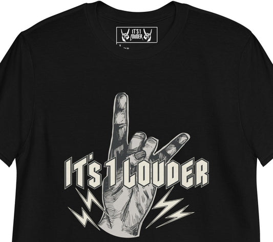 Black short sleeve shirt with a graphic of a hand doing the devil horns symbol for rock and roll. The words IT'S 1 LOUDER is written across the hand in a beige colour. The hand is of light grey colour. 4 small bolts of lightning are at the bottom of the palm and below the words "It's 1 Louder". Also shown, is the inside label of the T-shirt that shows two hands doing the rock symbol. In between the 2 hands is written the words: It's 1 Louder.